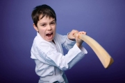 A Caucasian teenage boy in white kimono standing in fighting pose with wooden katana sword. Aikido fighter. Oriental martial arts concept
